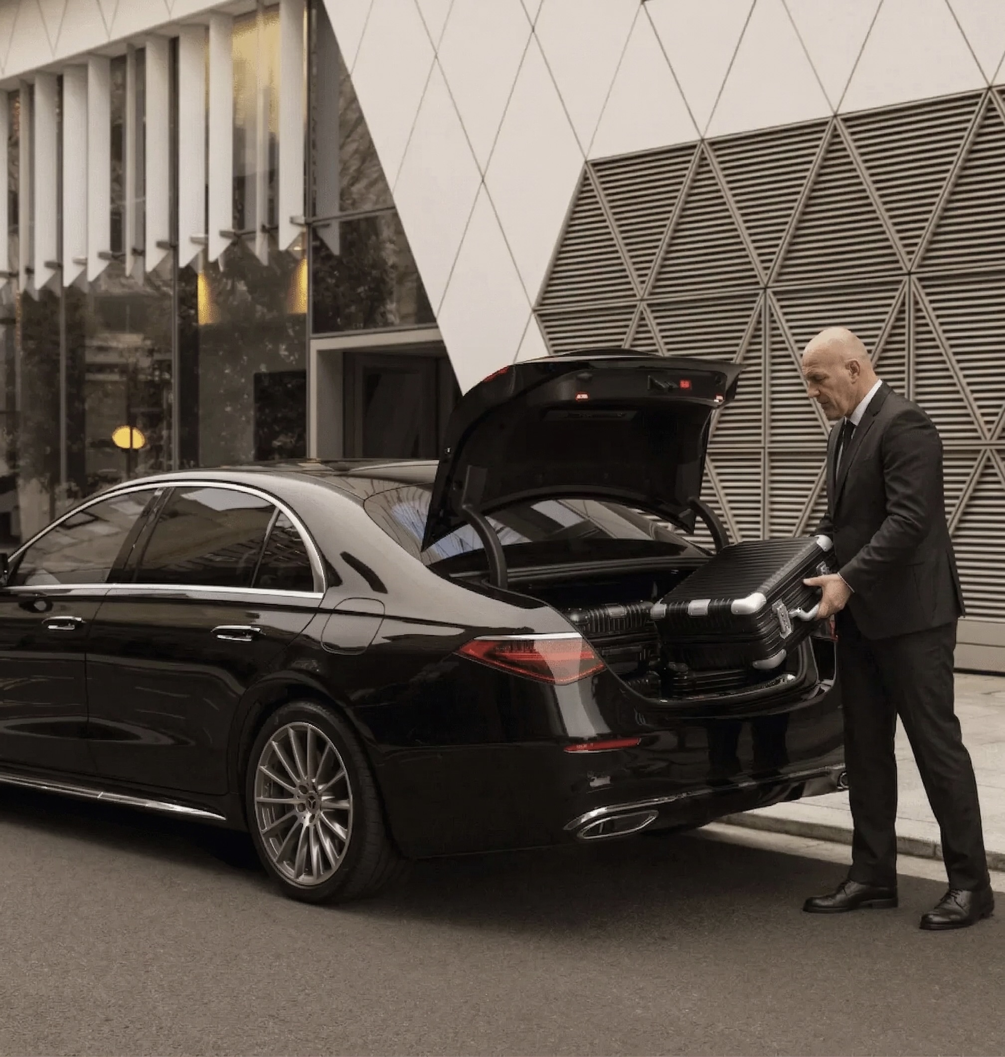 Chauffeur loading luggage into Mercedes-Benz S-Class